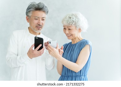 Middle Aged Asian Couple Using Smart Phone