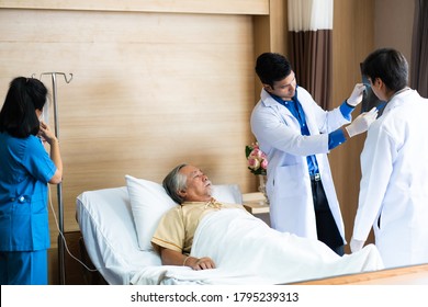 Middle Aged Asian Male Doctor And Nurse Talking About The Illness Of The Senior Elderly Man Patient On The Hospital Bed