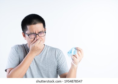 Middle Aged Asian Man Blocking His Nose From Bad Smell Or The Pain From Wearing Mask All Day