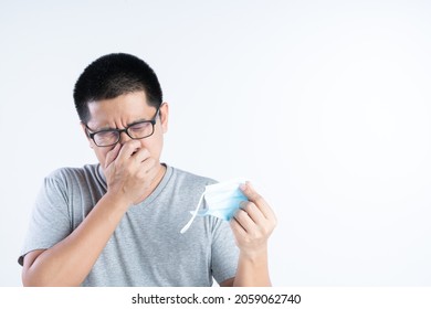 Middle Aged Asian Man Blocking His Nose From Bad Smell Or The Pain From Wearing Mask All Day