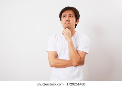 Middle Aged Asian Man With Confused Expression Isolated On White Background.