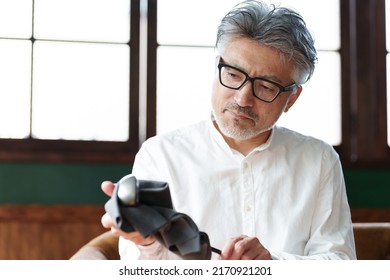 Middle Aged Asian Man Taking Care Of Golf Club