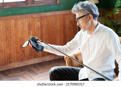 Middle Aged Asian Man Taking Care Of Golf Club