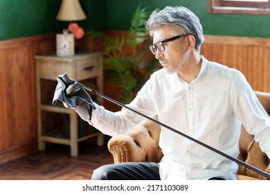 Middle Aged Asian Man Taking Care Of Golf Club