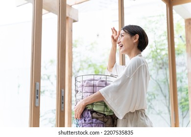 Middle Aged Asian Woman Doing Laundry