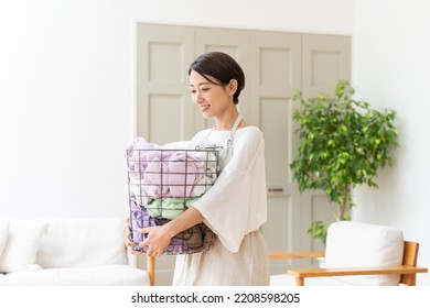 Middle Aged Asian Woman Doing Laundry