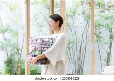 Middle Aged Asian Woman Doing Laundry