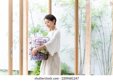 Middle Aged Asian Woman Doing Laundry