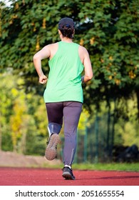 Middle Aged Asian Woman Running On Red Race Track, Healthy Fitness Lifestyle