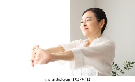 Middle Aged Asian Woman Stretching Soaking Up The Sun 