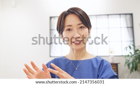 Middle aged Asian woman talking with video calling. Live distribution.