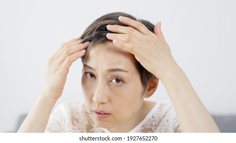 Middle Aged Asian Woman Worrying About Her Hair. Beauty Concept. Thinning Hair. Hair Care.