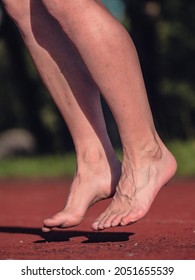 Mittelalter barfuß springende Frau wärmen die Muskeln und streckt Körper auf Stadionlauf Bahn. Echte Menschen treiben Sport