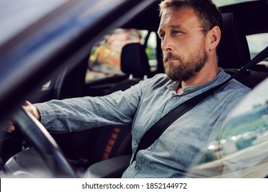 Middle Aged Bearded Man Sitting In His Car And Driving It.