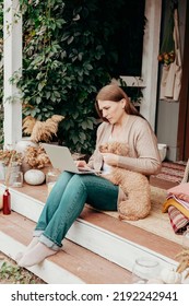 Middle Aged Beautiful Woman Plus Size Model In Jeans And Knitted Cardigan And Dog Sit On Porch Rustic Country Cosy House Using Laptop, Autumn Weather, Mental Health, Online Work