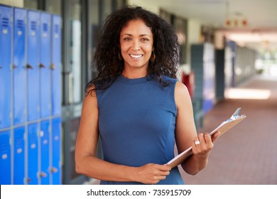 Middle aged black female teacher smiling in school corridor
