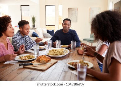 Middle Aged Black Man Sitting At The Table Eating Dinner With His Wife And Family, Close Up