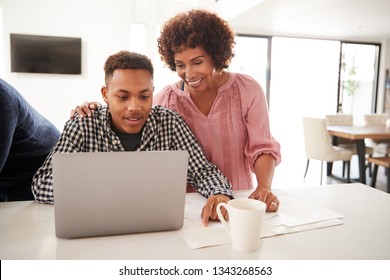 Middle Aged Black Mum Helping Her Teenage Son Do His Homework Using A Laptop, Close Up