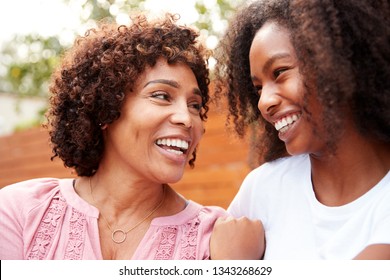 Middle Aged Black Mum And Teen Daughter Smiling At Each Other