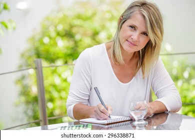 Middle Aged Blond Woman Working At Home Without Stress