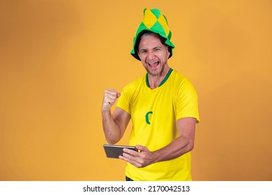 middle aged brazilian fan man watching game by smartphone - Powered by Shutterstock