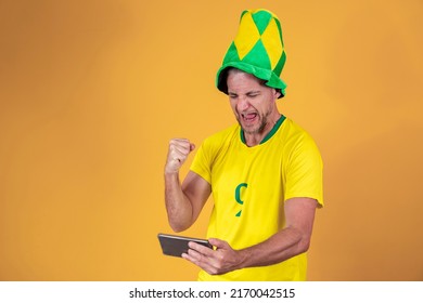 middle aged brazilian fan man watching game by smartphone - Powered by Shutterstock