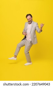 Middle Aged Business Man Musician Pretend Playing Guitar Happy Smiling Isolated On Yellow Background. Handsome Mature Businessman In White Suit. Business Concept. Music Concept. 