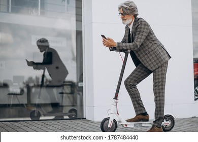 Middle Aged Business Man Riding Scooter In A Classy Suit