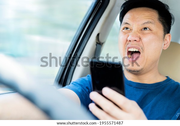A\
middle aged caucasian man distracted driving while using a mobile\
device stops his vehicle suddenly to avoid an\
accident.