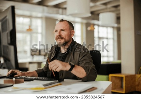 Middle aged caucasian man using a computer at a office job