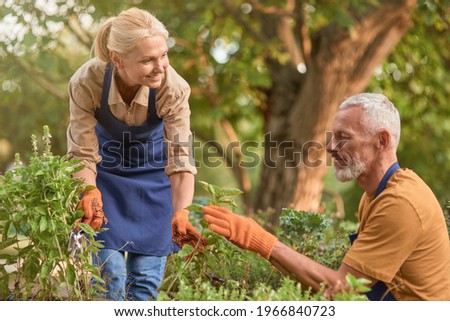Middle aged caucasian man and woman checking plants