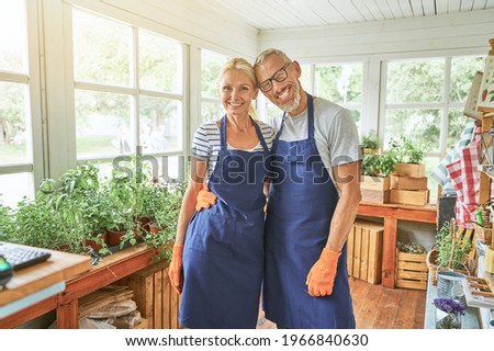 Middle aged caucasian spouses standing in garden house