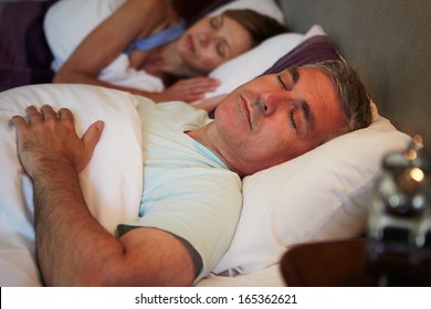 Middle Aged Couple Asleep In Bed Together