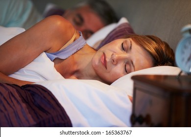 Middle Aged Couple Asleep In Bed Together