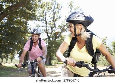 Middle Aged Couple Cycling Through Countryside