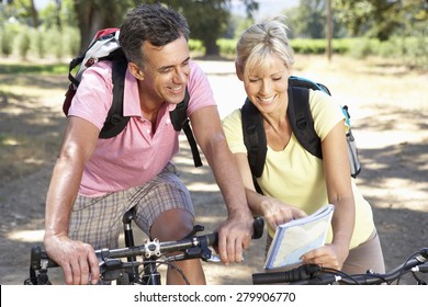 Middle Aged Couple Cycling Through Countryside