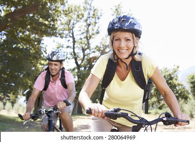 Middle Aged Couple Cycling Through Countryside