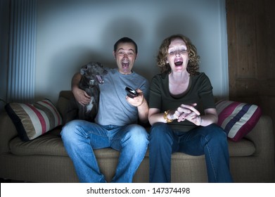middle aged couple and dog laughing at the television - Shutterstock ID 147374498