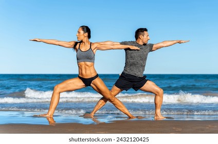 Middle aged couple exercising together on the beach this summer - Powered by Shutterstock