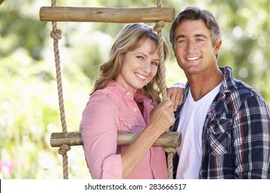 Middle Aged Couple In Garden By Treehouse