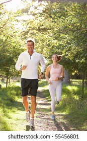 Middle Aged Couple Jogging In Park