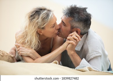 Middle Aged Couple Kissing At The Beach