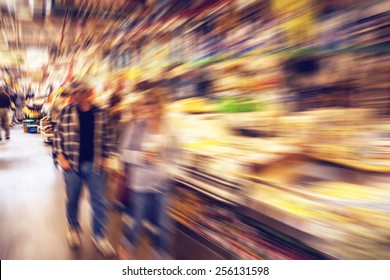 Middle aged couple shopping for groceries in a public market -  radial zoom effect defocusing filter applied, with vintage instagram look