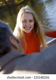 Middle Aged Couple Sitting By Water In A Boat