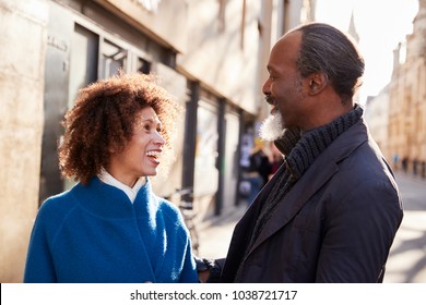 Middle Aged Couple Walking Through City In Fall Together