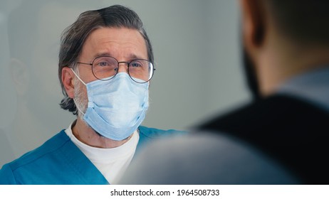 Middle Aged Doctor Interviewing Patient On Reception