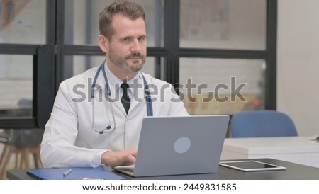 Middle Aged Doctor Shaking Head in Denial at Work