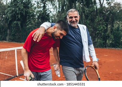 middle aged father with his son on tennis court - Powered by Shutterstock