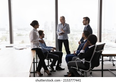 Middle Aged Female Business Coach Training Interns, Talking To Diverse Group On Corporate Briefing. Senior Female Leader And Employees Meeting, Diccussing Project, Brainstorming