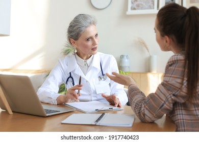 Middle Aged Female Doctor Therapist In Consultation With Patient In Office